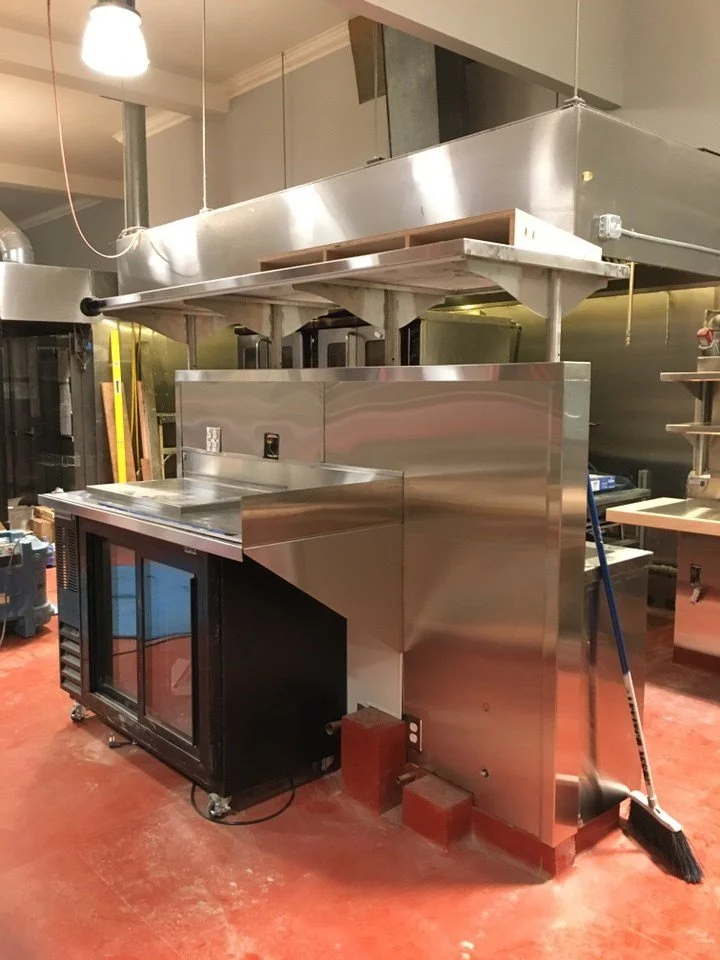 New stainless steel cooking and refrigeration equipment installed at Arizmendi Bakery, reflecting durable materials selected for high volume commercial food production.
