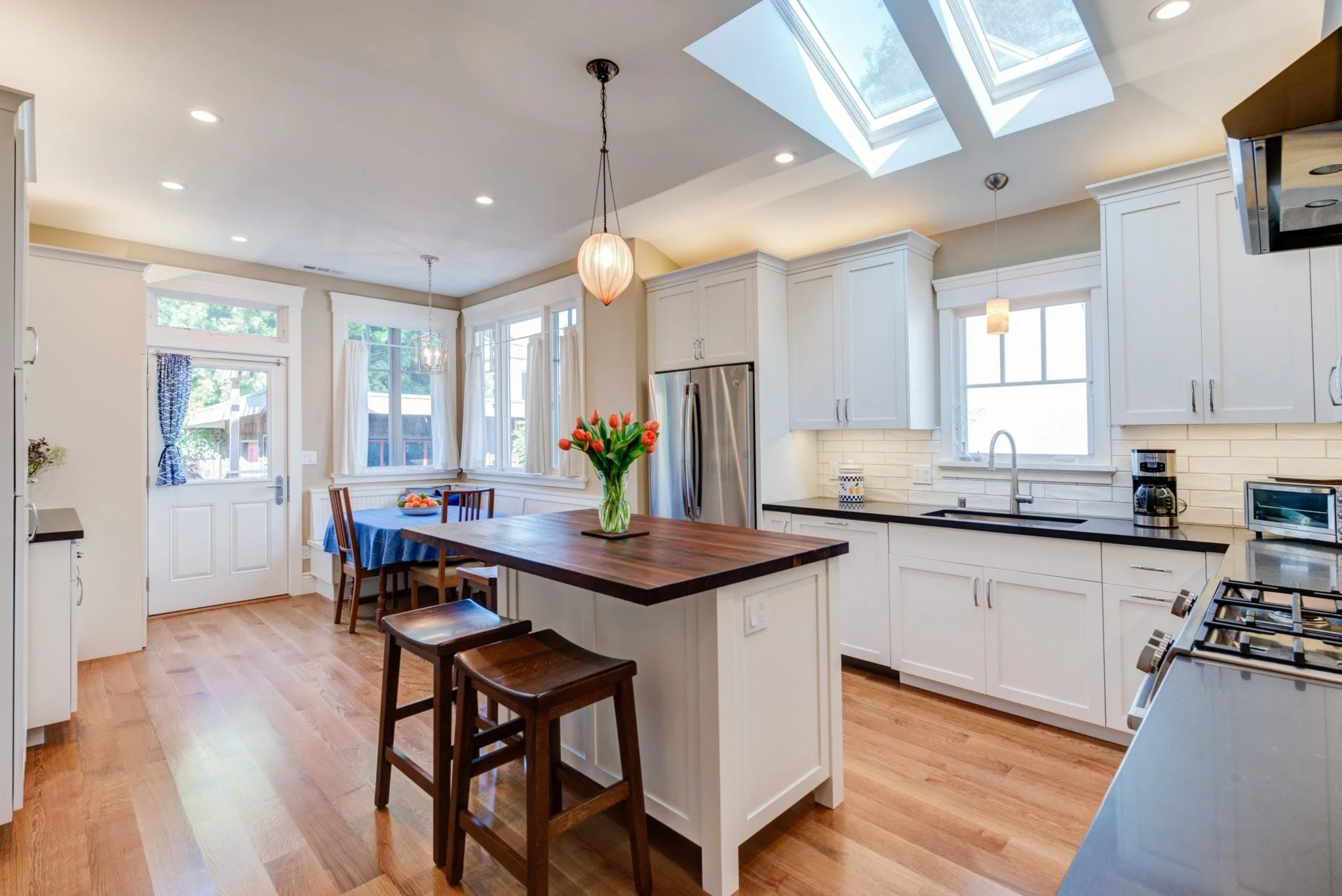Kitchen island view toward casual dining nook in Craftsman remodel