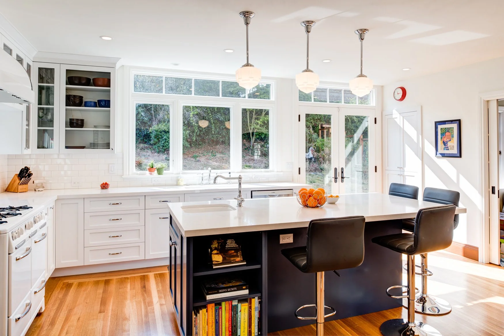 Remodeled black-and-white kitchen with expanded layout from an 11-square-foot addition, featuring updated cabinetry, modern appliances, and classic accents after removing the nook and relocating the powder room.