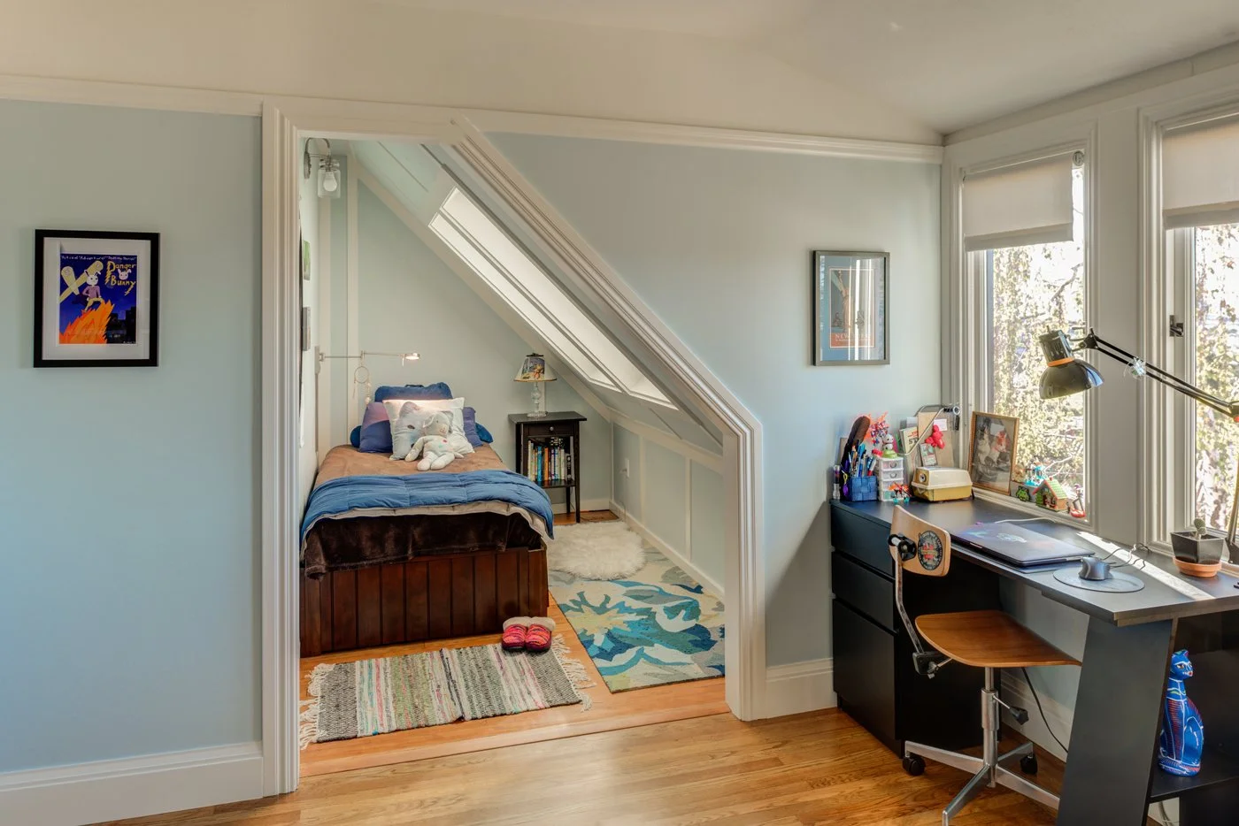 Upper story bedroom reconfigured for better use of the dormer space, showing an alcove bed under the sloped ceiling and a built in desk area with large corner windows.