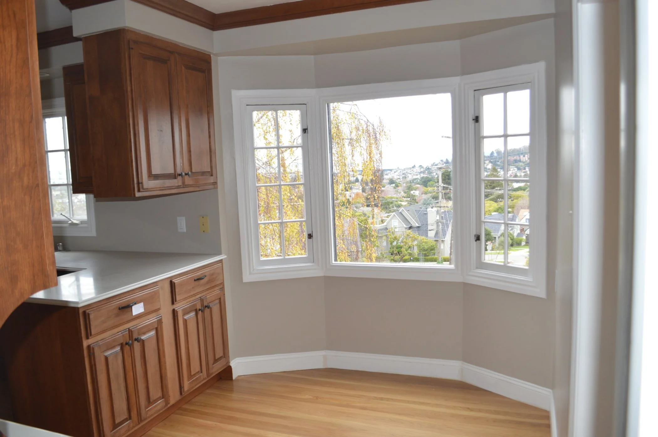 Breakfast nook before renovation, showing bay windows and the previous kitchen corner that limited movement, prior to widening the opening between dining room and nook.