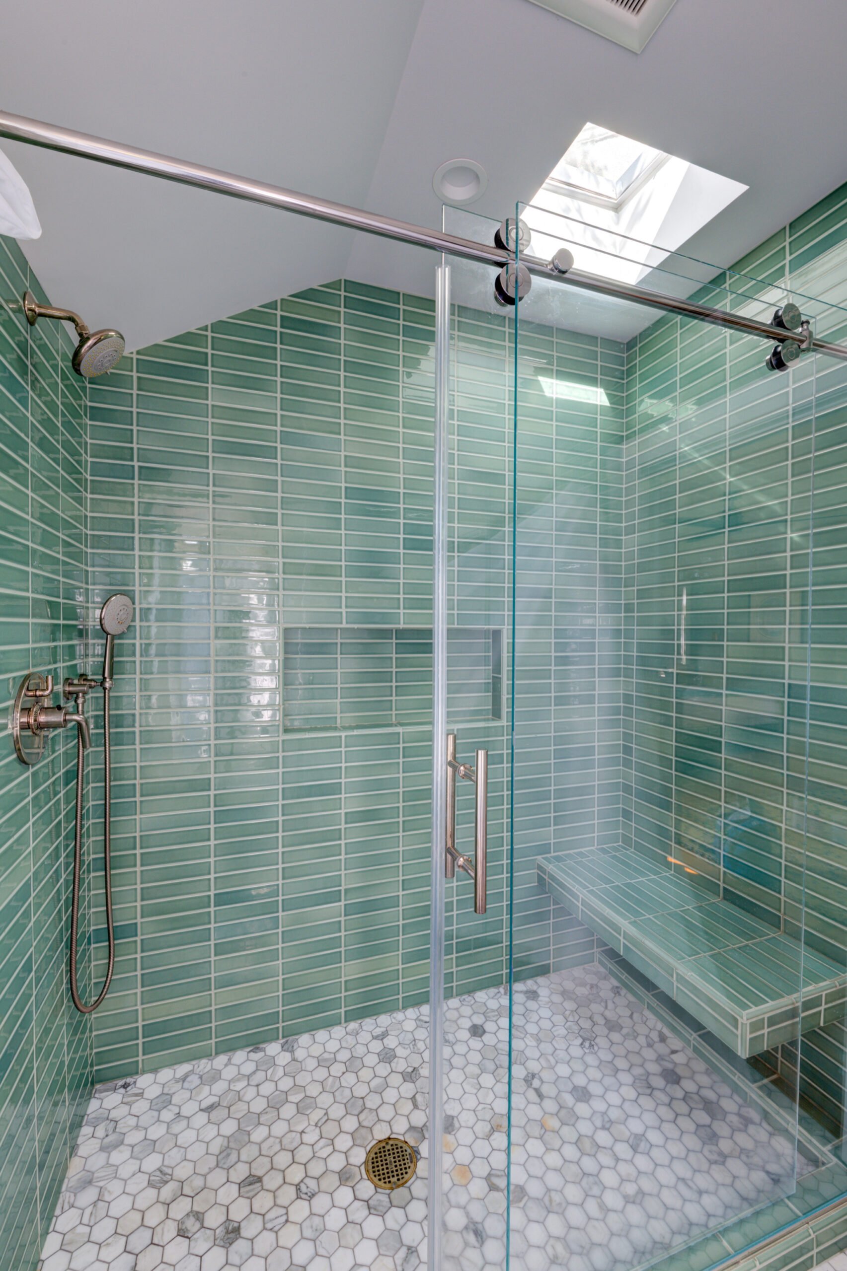 Shower with tile and glass enclosure.