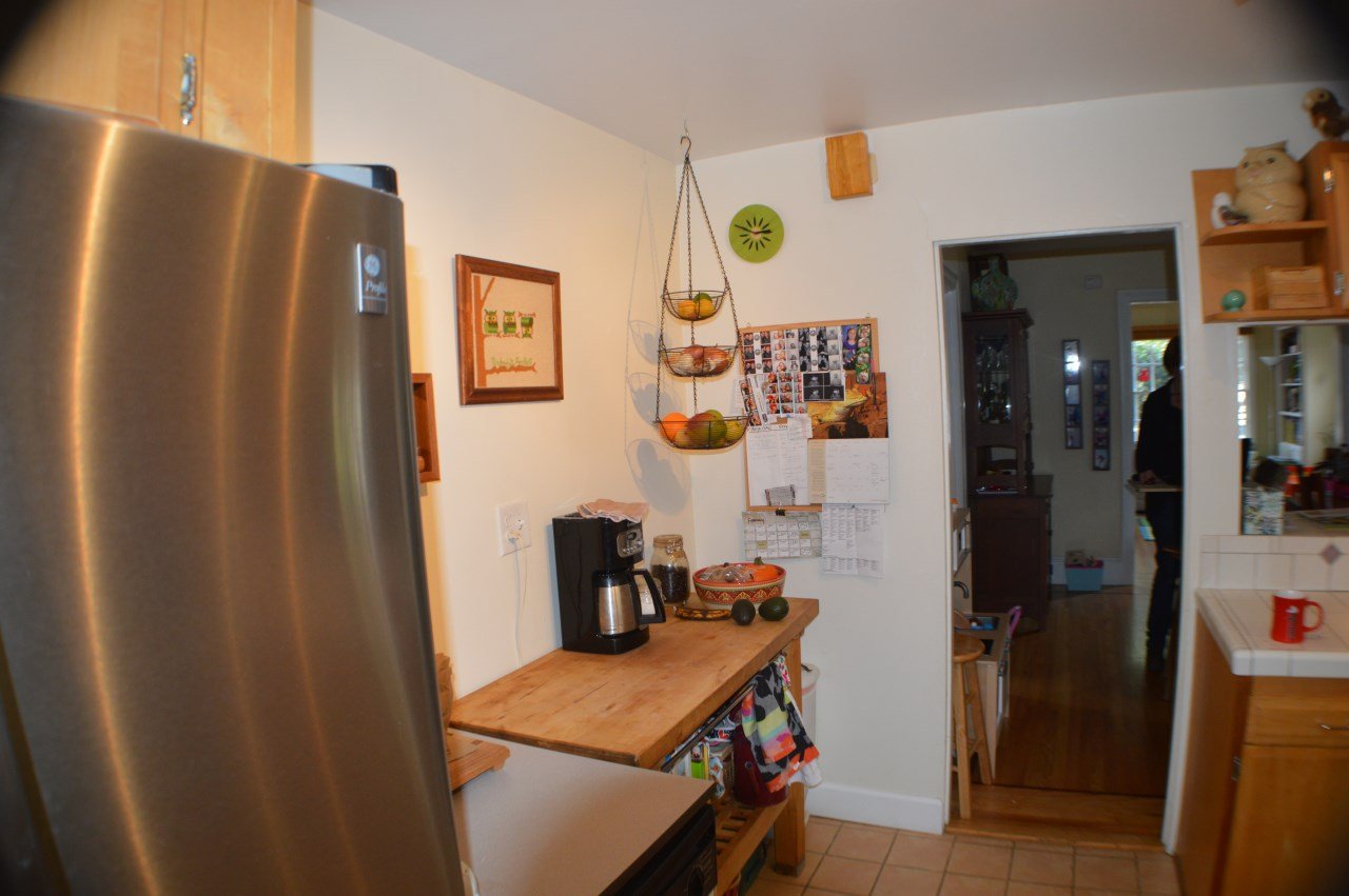 Original kitchen before renovation with dated cabinetry, tiled counters, and limited workspace, documenting conditions prior to the Lighthearted Kitchen Addition.
