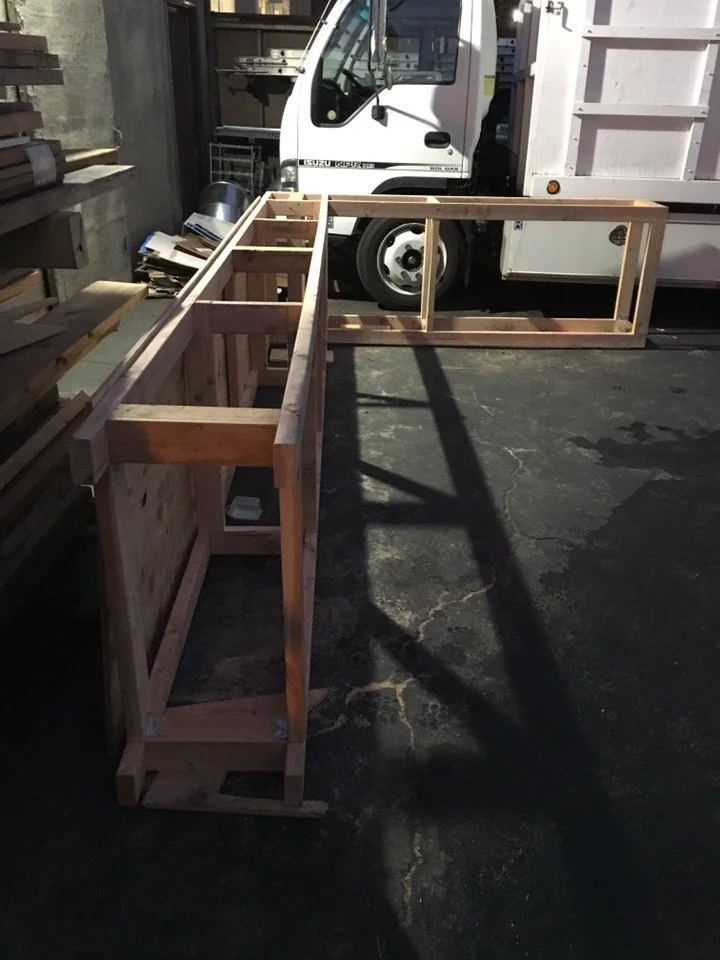 Curved wood service counter under construction, showing integrated storage and work surfaces that support efficient customer service and improve accessibility at the point of sale.