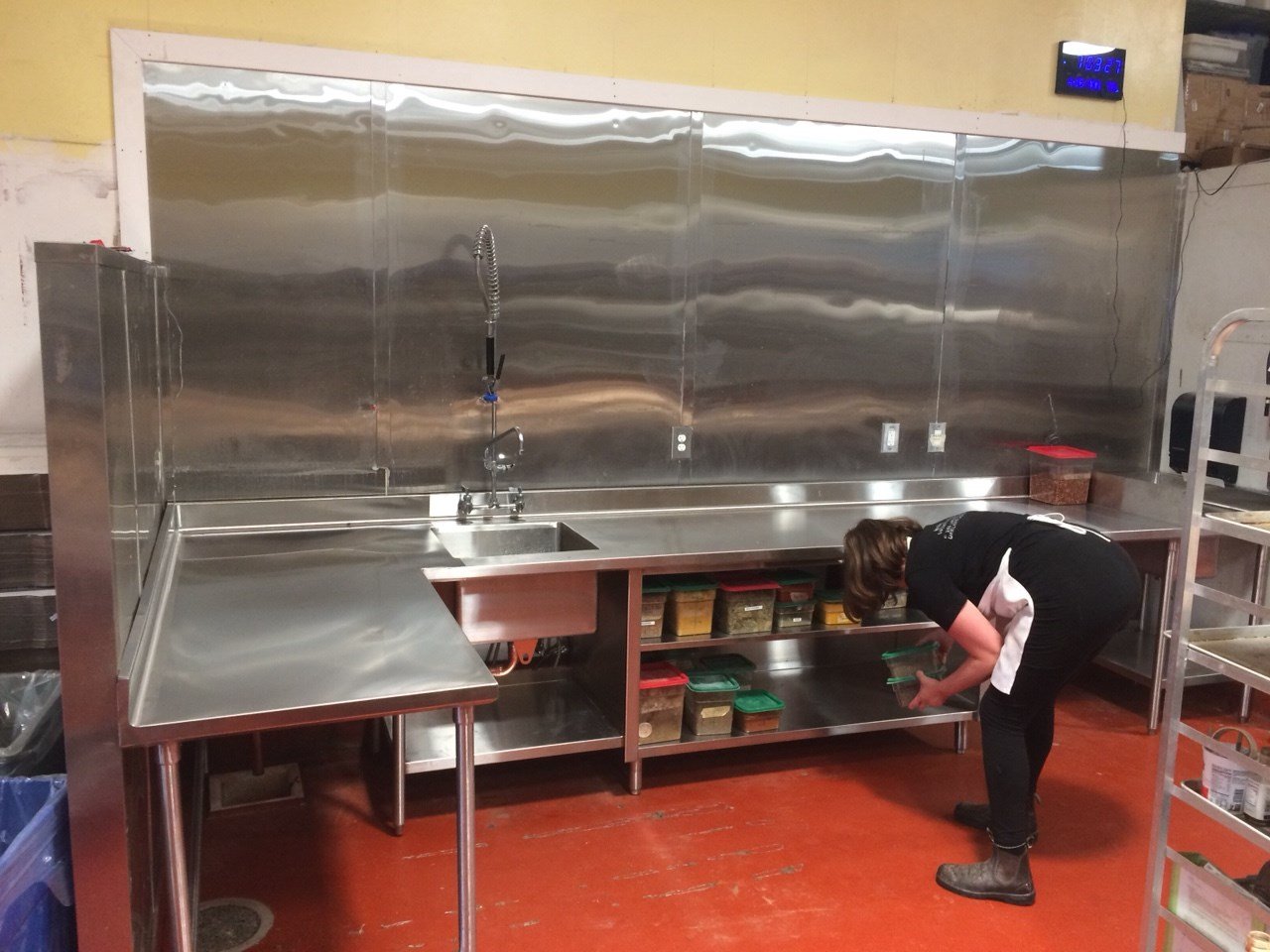 Stainless steel commercial sink and prep counter at Arizmendi Bakery with open shelving below, supporting food safety, organization, and efficient daily kitchen operations.