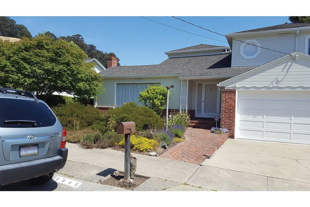 Front exterior view before remodel, with entry walkway and garage