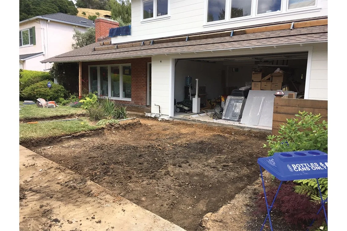 Driveway excavation in front yard, dirt exposed for new paving