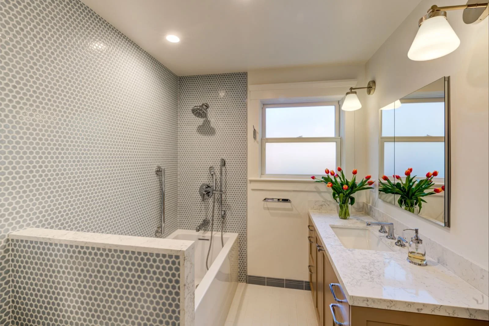 Remodeled Bathroom with custom vanity cabinet and hexagonal tile at the tub/shower enclosure