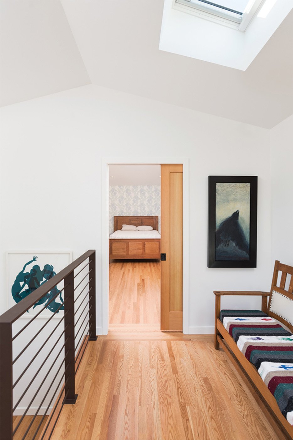 Stair landing to second story showing skylight and modern handrail