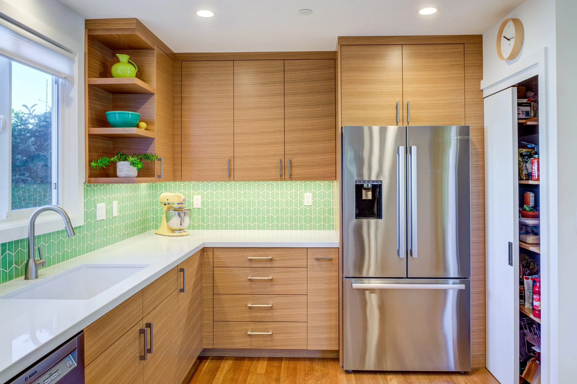 Kitchen pantry revealed with open door, displaying organized storage within custom cabinetry that maximizes function while maintaining a clean modern kitchen design.