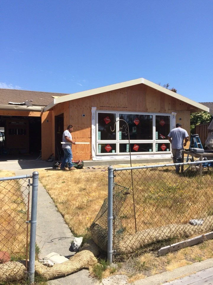 Exterior view of the Alameda waterfront addition under construction with new wall framing and window openings positioned to capture water views.
