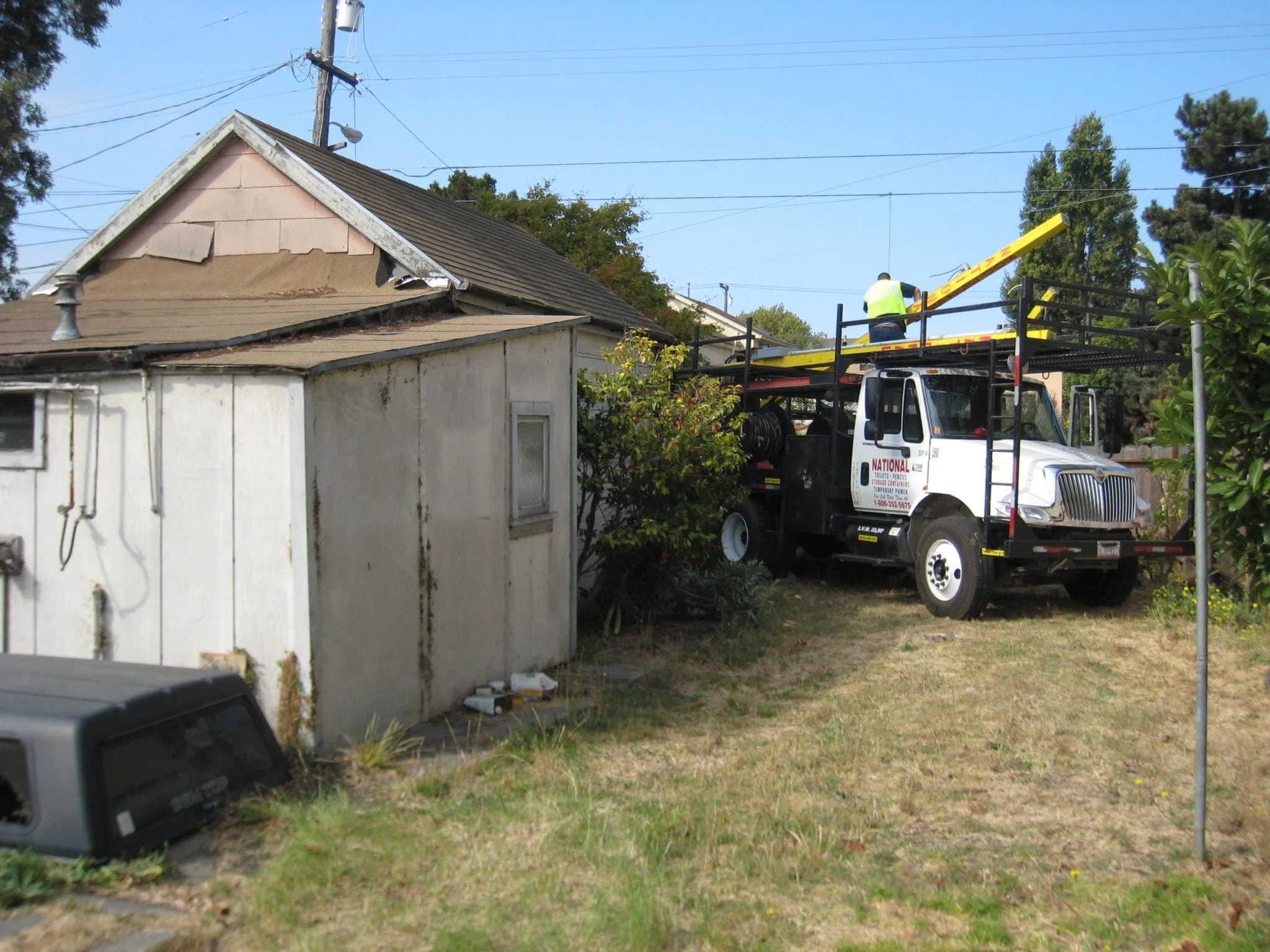 Existing backyard structure and utility truck prior to redevelopment, documenting site preparation and early-stage work before construction of the Green Development Project began.