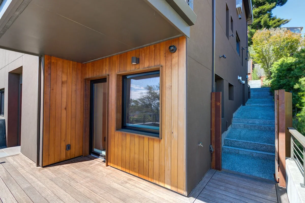 This is the front of the ADU. Deep window recesses that the Owner requested are visible at the right side of the home, and provide shading and visual interest. The deck extends over the new Garage to make the most of outdoor space on this sloping sit