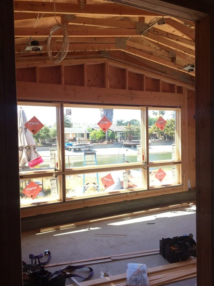 Interior view of the addition framing showing vaulted ceiling structure and large window openings designed to maximize daylight and views.