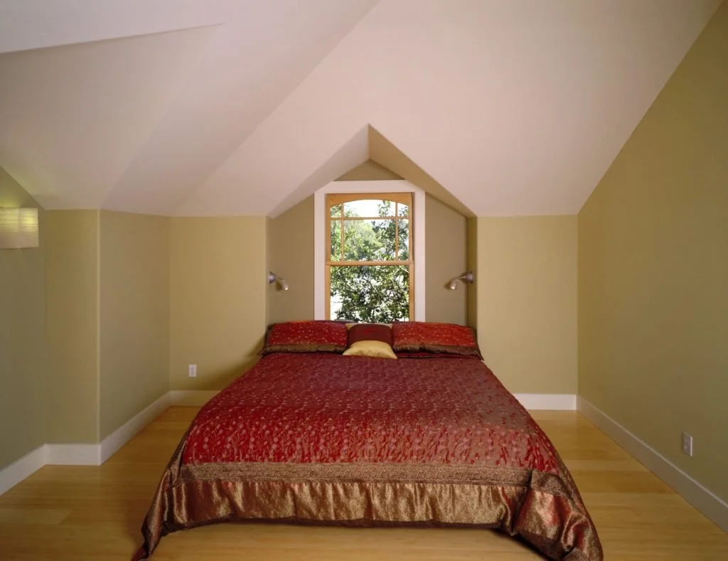 New bedroom with vaulted ceiling and generous windows, bringing in natural light and passive solar warmth near the stair, created during Levitch phased Berkeley remodel and second-floor addition.