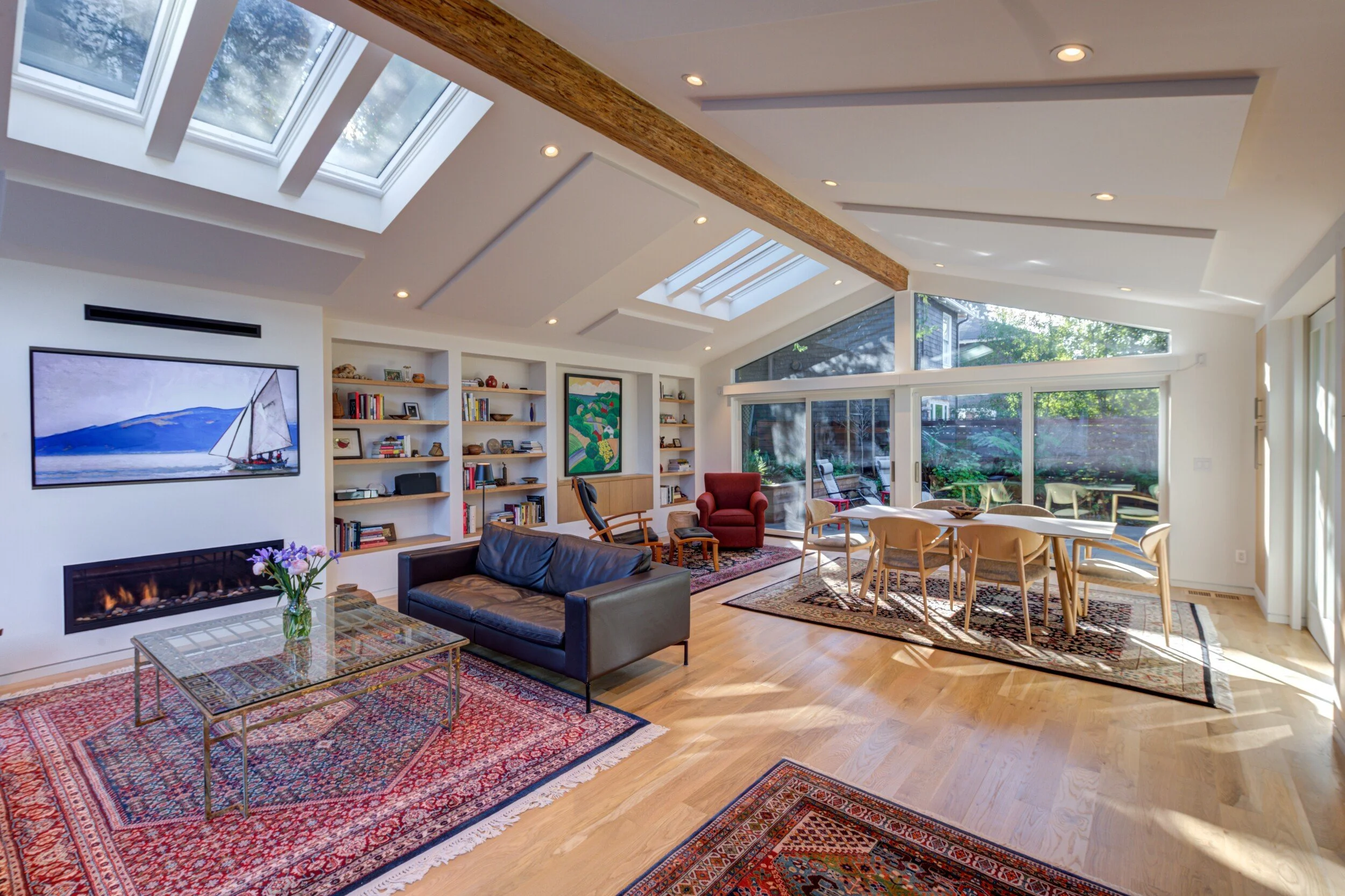 New Living Room, completely opened up with a new ridge beam, skylights and lots of glass at either end. Sound dampening panels are mounted at the ceiling.