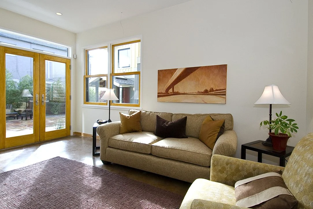 Living area with seating, side tables, and patio doors that open to the outdoor space, supporting flexible use and strong indoor outdoor connection.
