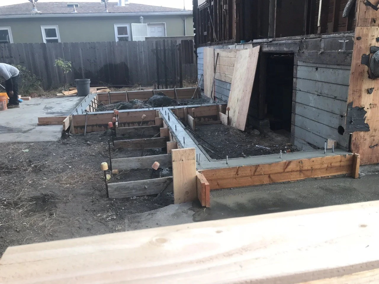 New concrete footings and rebar forming the structural base for the residential lift addition in Berkeley home renovation.