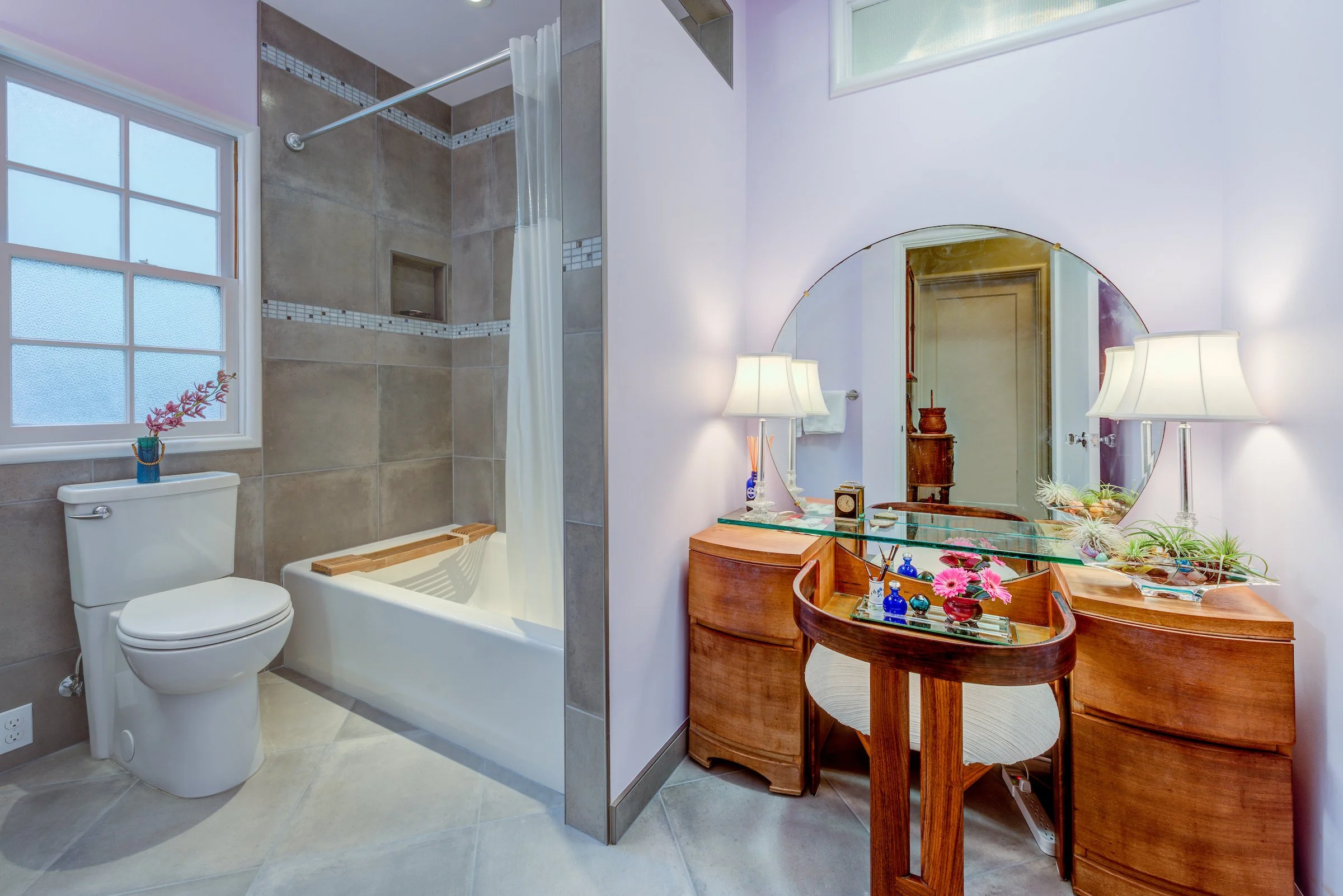 Full New Bathroom with lavender walls, grey floor and shower tiles, and vanity beside the shower.