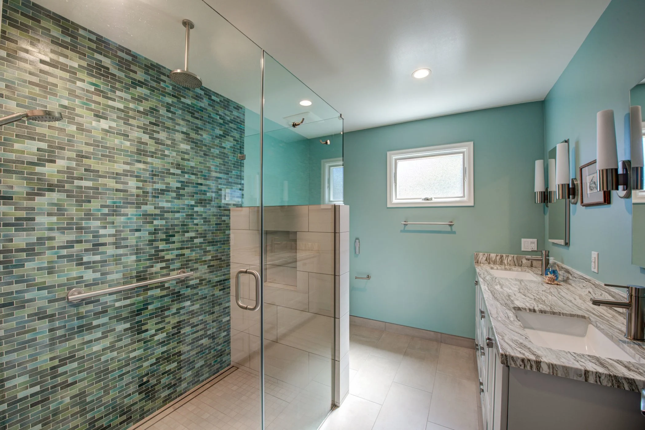 Primary bathroom with a curb-less walk-in shower, mosaic tile accent wall, grab bars, and improved accessibility designed for aging in place.