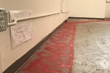 Marked floor showing sawcut path for new plumbing at BIBO Salon