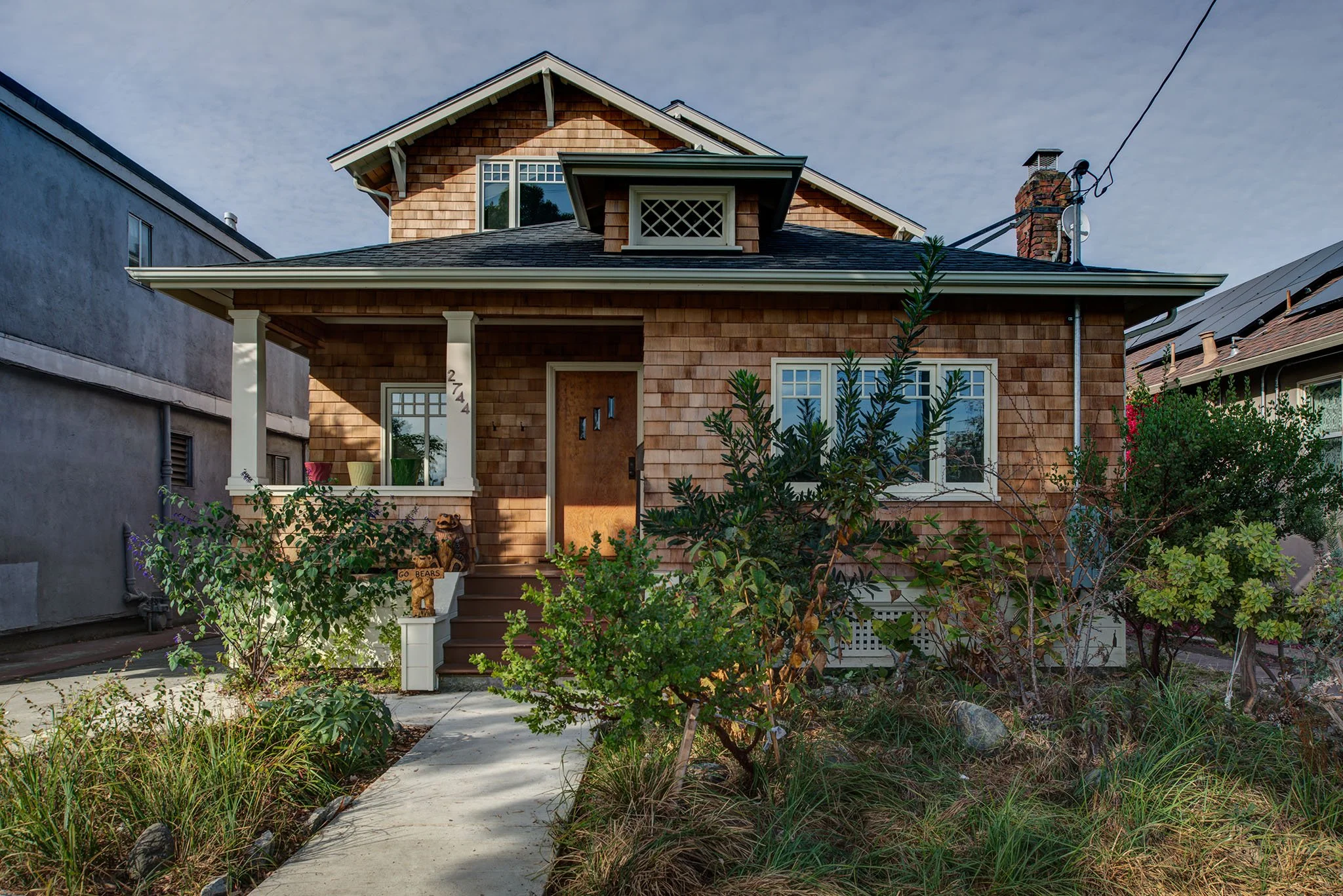 Front exterior of the Craftsman bungalow after Levitch updates, with a welcoming porch, cedar shingles, and improved windows that keep the original neighborhood character.