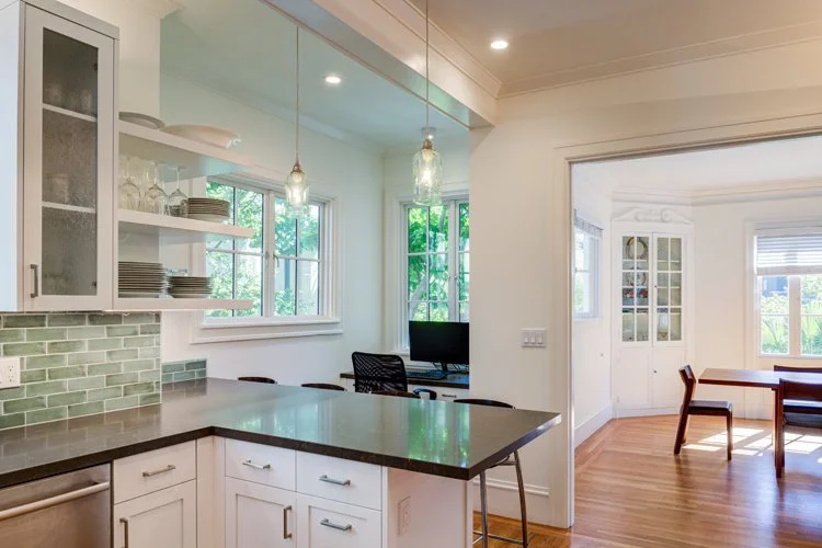 Kitchen peninsula looking toward the former nook, now a built-in home office area under the window, creating a visual connection and flexible use between kitchen, dining, and work spaces.