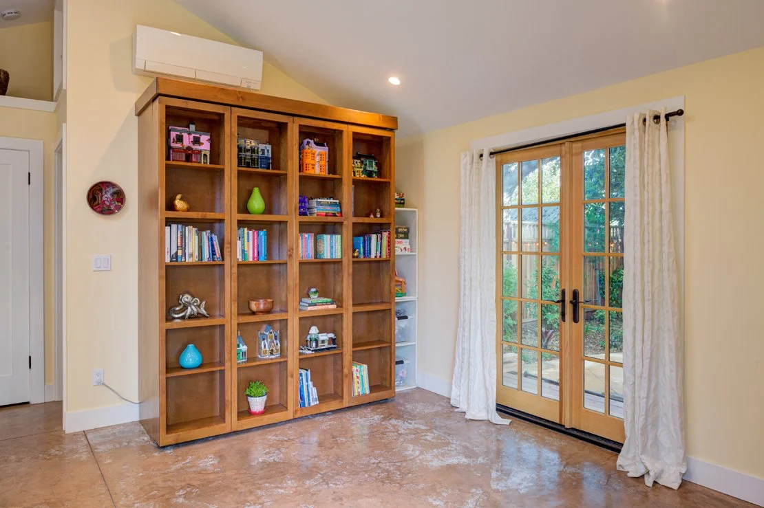 ADU sleeping area with Murphy bed out of sight. Floors are stained concrete to keep construction costs lower.