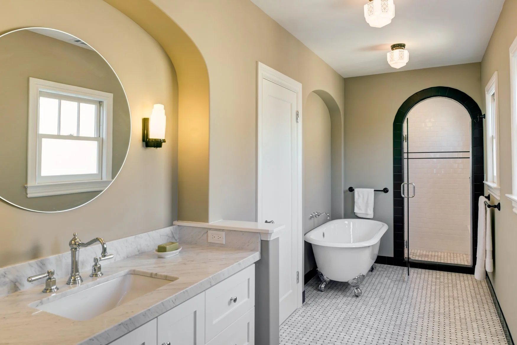 Primary bathroom remodel with classic black-and-white finishes, arched niche details, and new separate shower and tub replacing the previous shower-only configuration.
