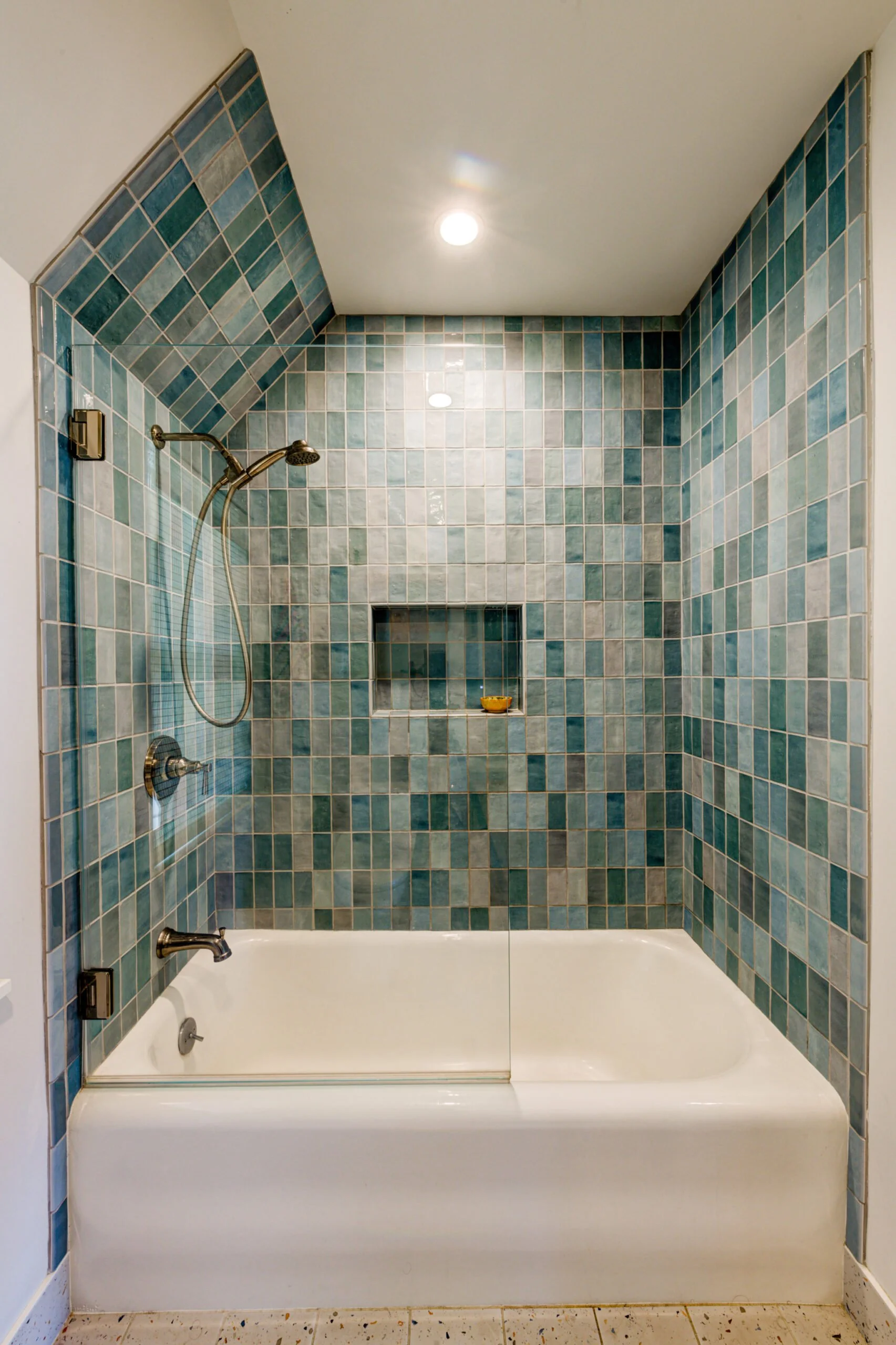 Shower with tile and glass enclosure.