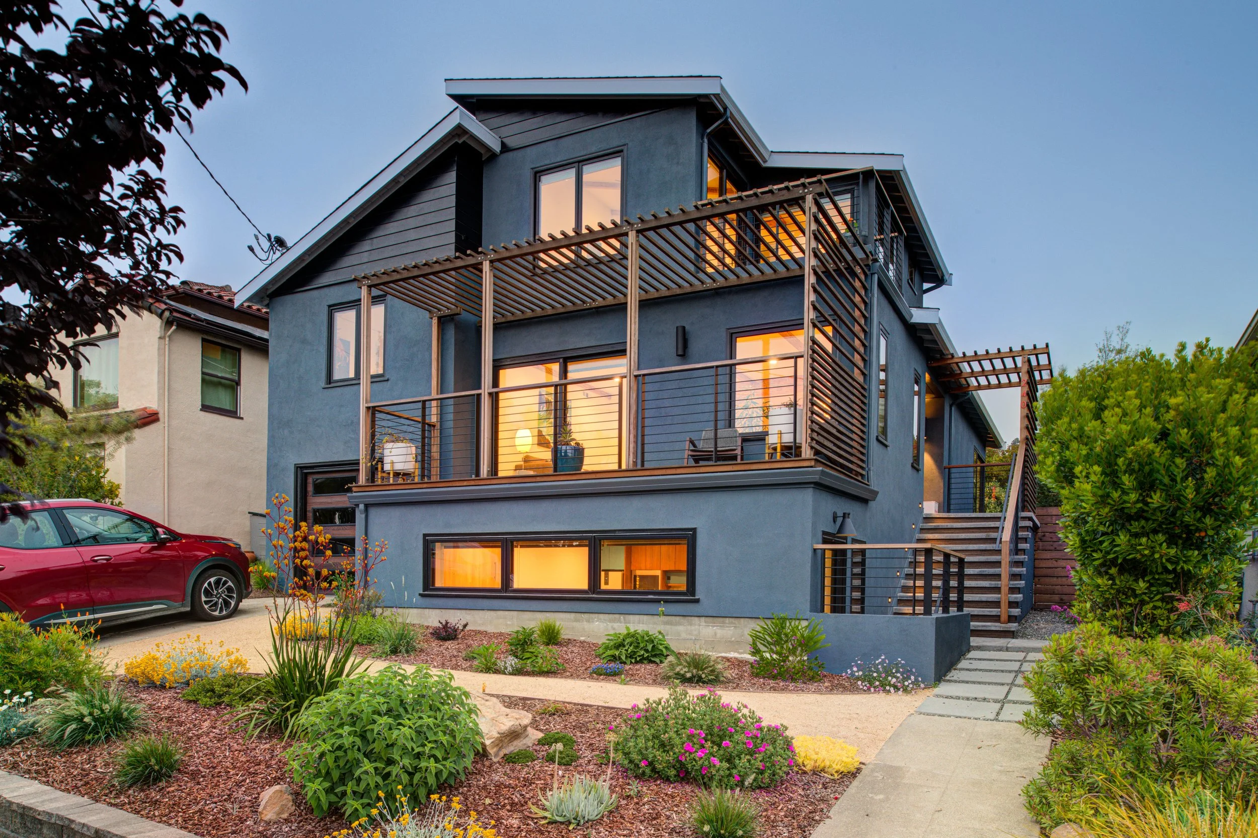 Midcentury home addition and attached ADU in El Cerrito, featuring a second-story deck, trellis, and landscaped yard.