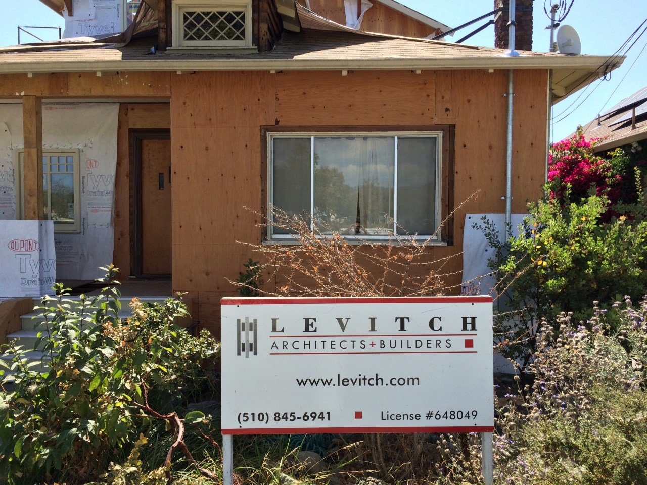 evitch Architects and Builders sign in front of the home during construction, documenting the Craftsman renovation and second story addition underway in Berkeley.