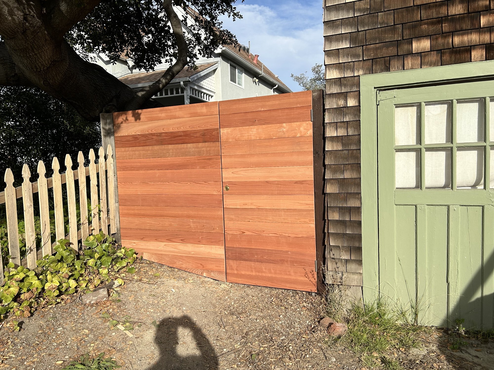 Custom horizontal wood gate installed between existing structures. The new gate improves privacy and access while matching the warm wood tones and scale of the renovated home.