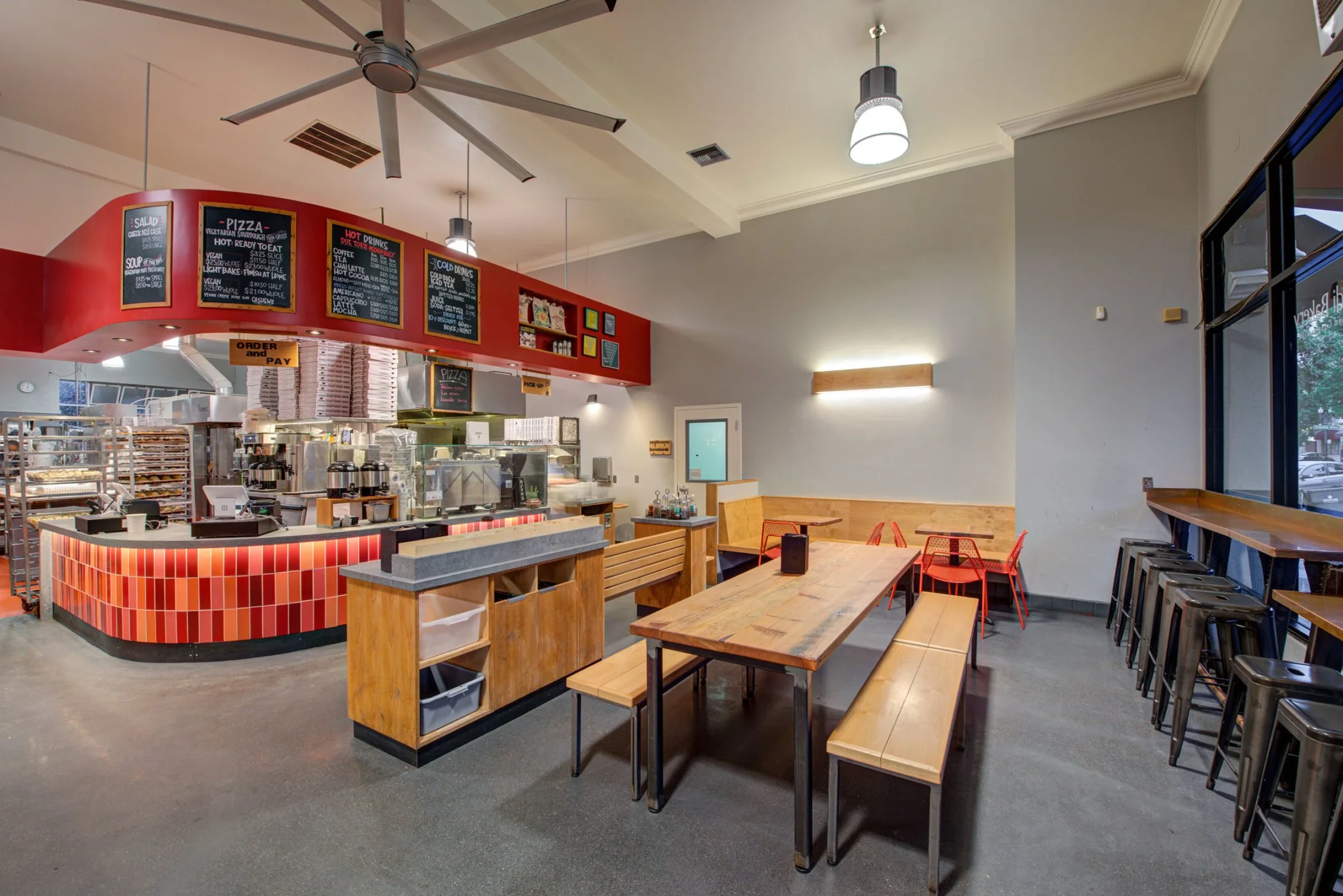 Arizmendi Bakery Customer Area with recycled wood tables, benches and window bar seating