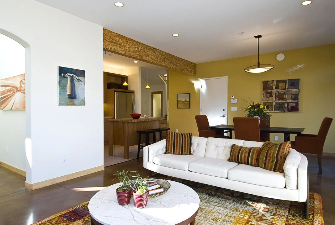 Living room perspective looking toward the kitchen and dining areas, illustrating the open plan layout, natural light, and cohesive flow throughout the main level.