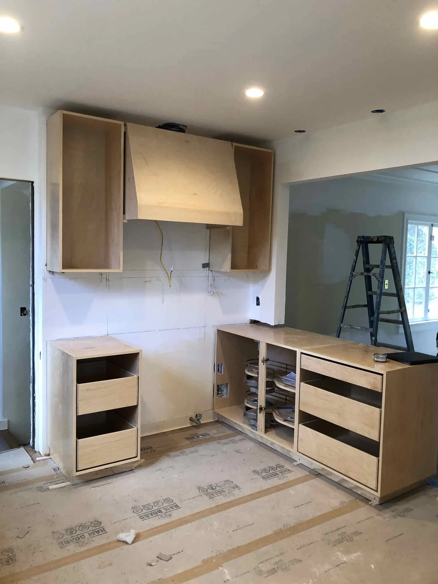 Kitchen layout under construction: framing, electrical rough-in and cabinetry shown.