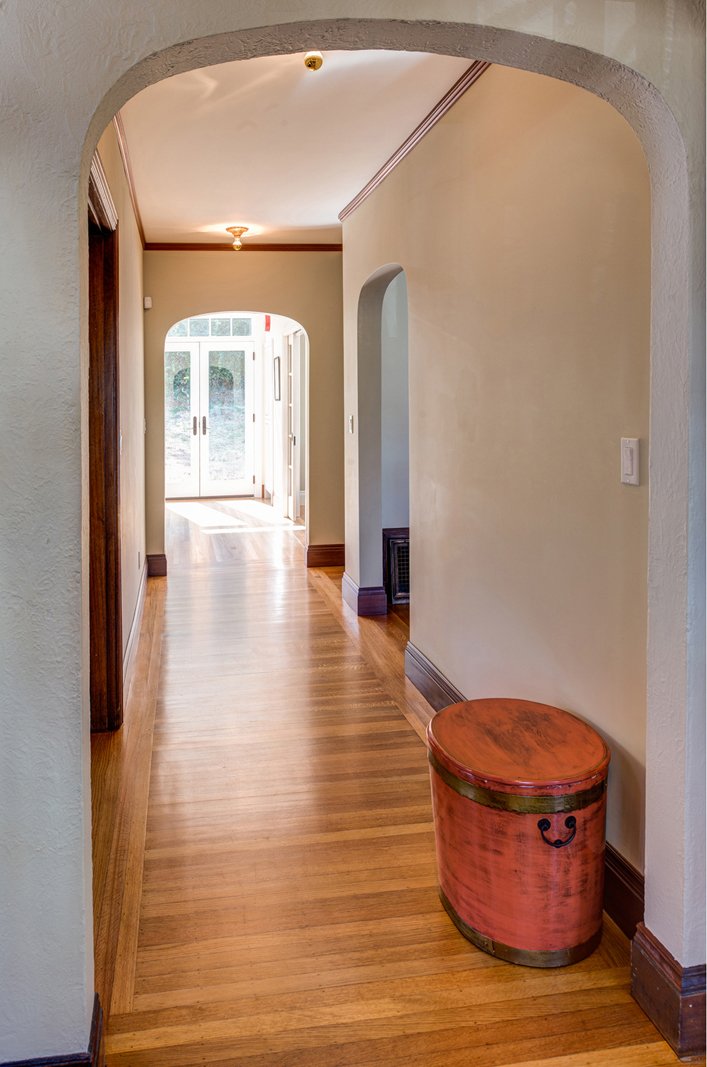Hallway showing arched doorways introduced during remodel, connecting the reworked bedroom and bathroom layout.