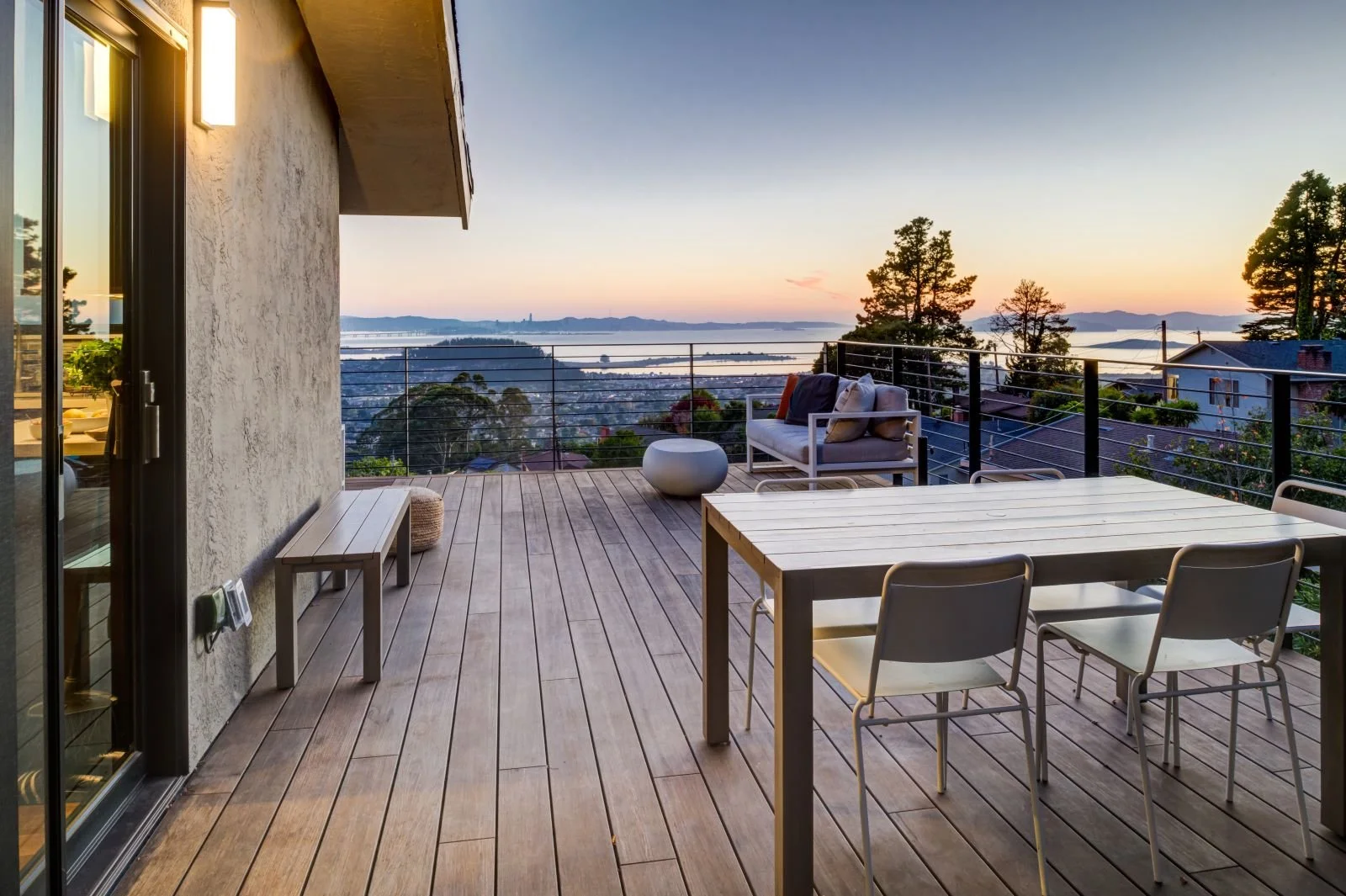 Outdoor dining and lounge areas are positioned at the edge of the deck, framing panoramic bay and sunset vistas and reinforcing the project’s focus on elevated, indoor–outdoor living.