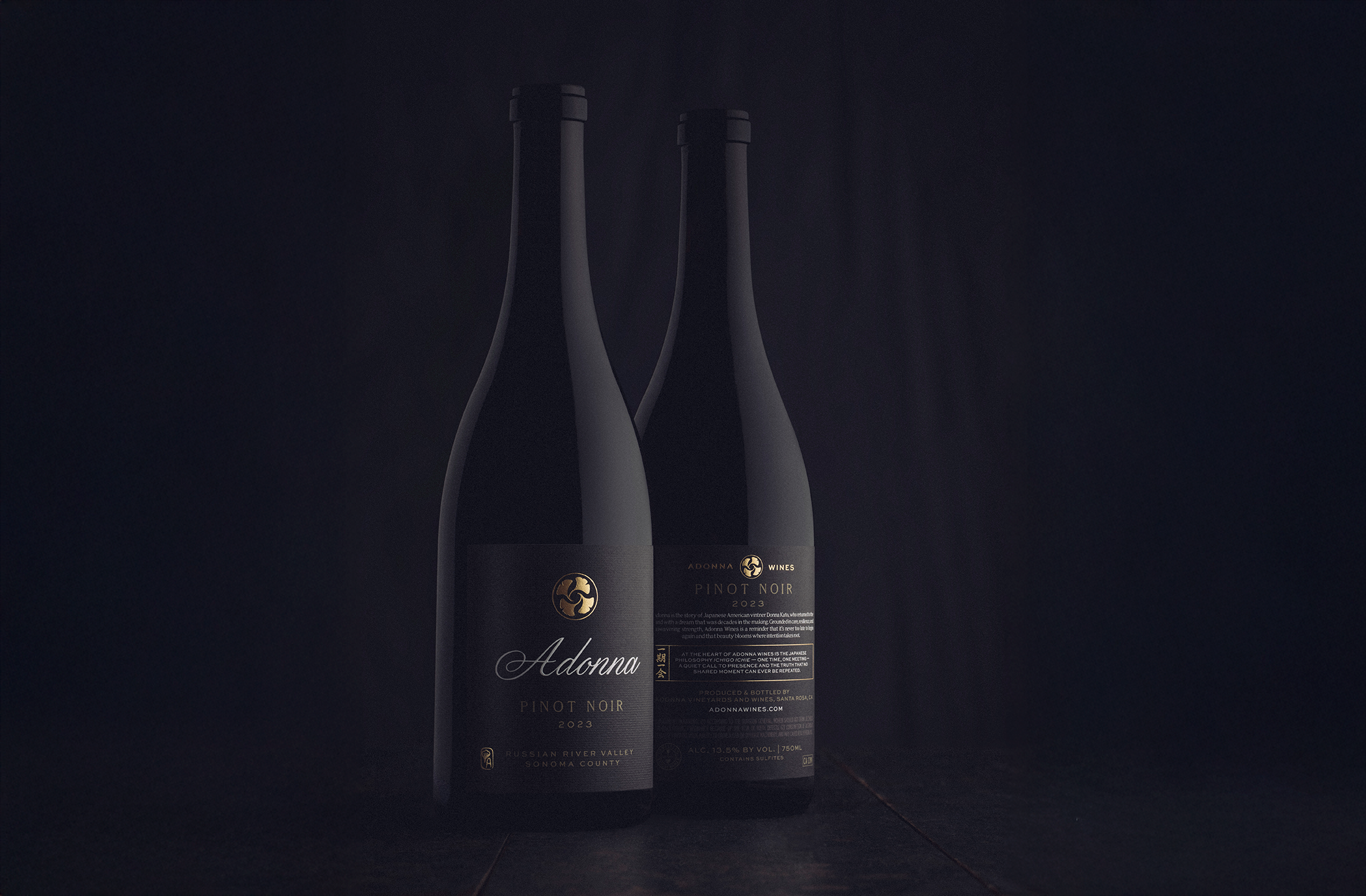 Two bottles of Adonna Pinot Noir 2023 wine against a dark background. The label on the front bottle is visible, displaying the brand name, wine type, and vintage year.