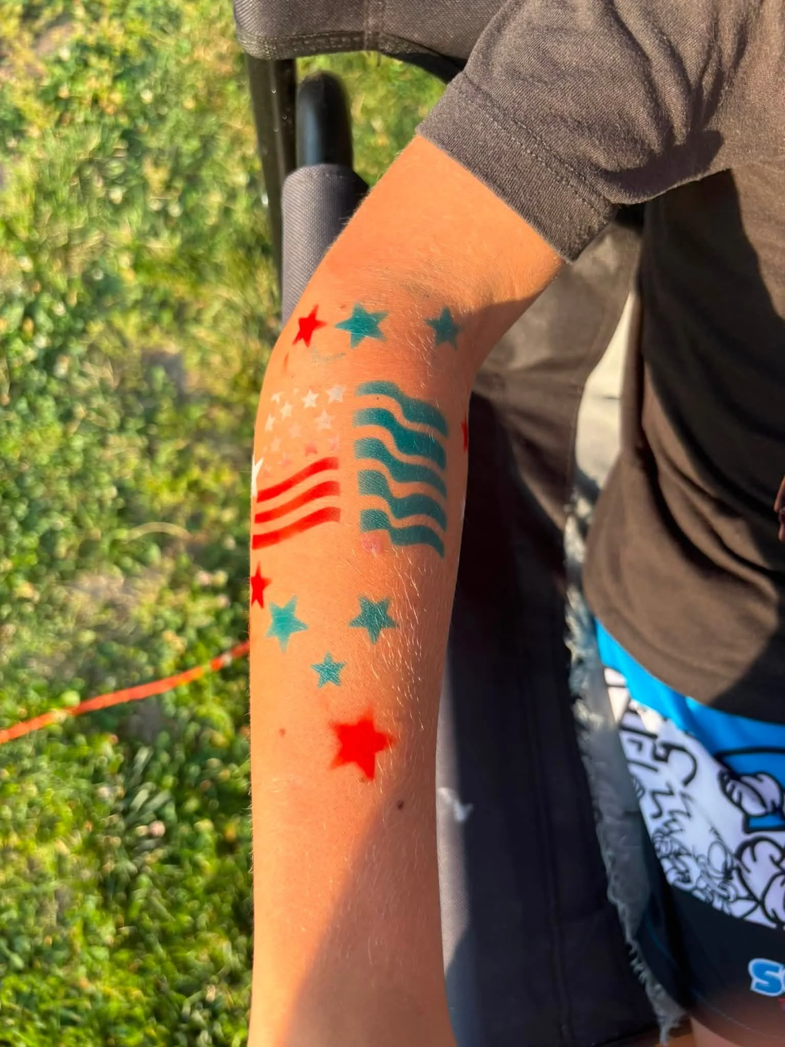 Close-up photo of a person's arm with colorful red white and blue 4th of July tattoo.