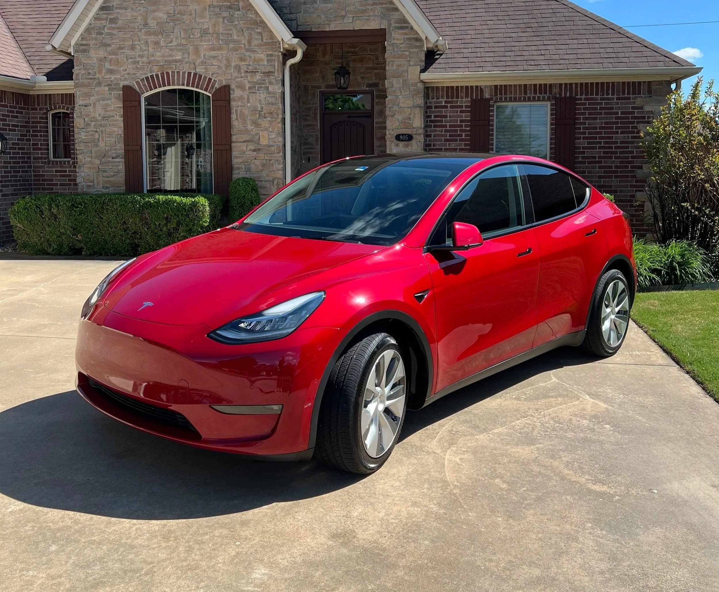 Paint correction results on a red Tesla Model Y after exterior detailing