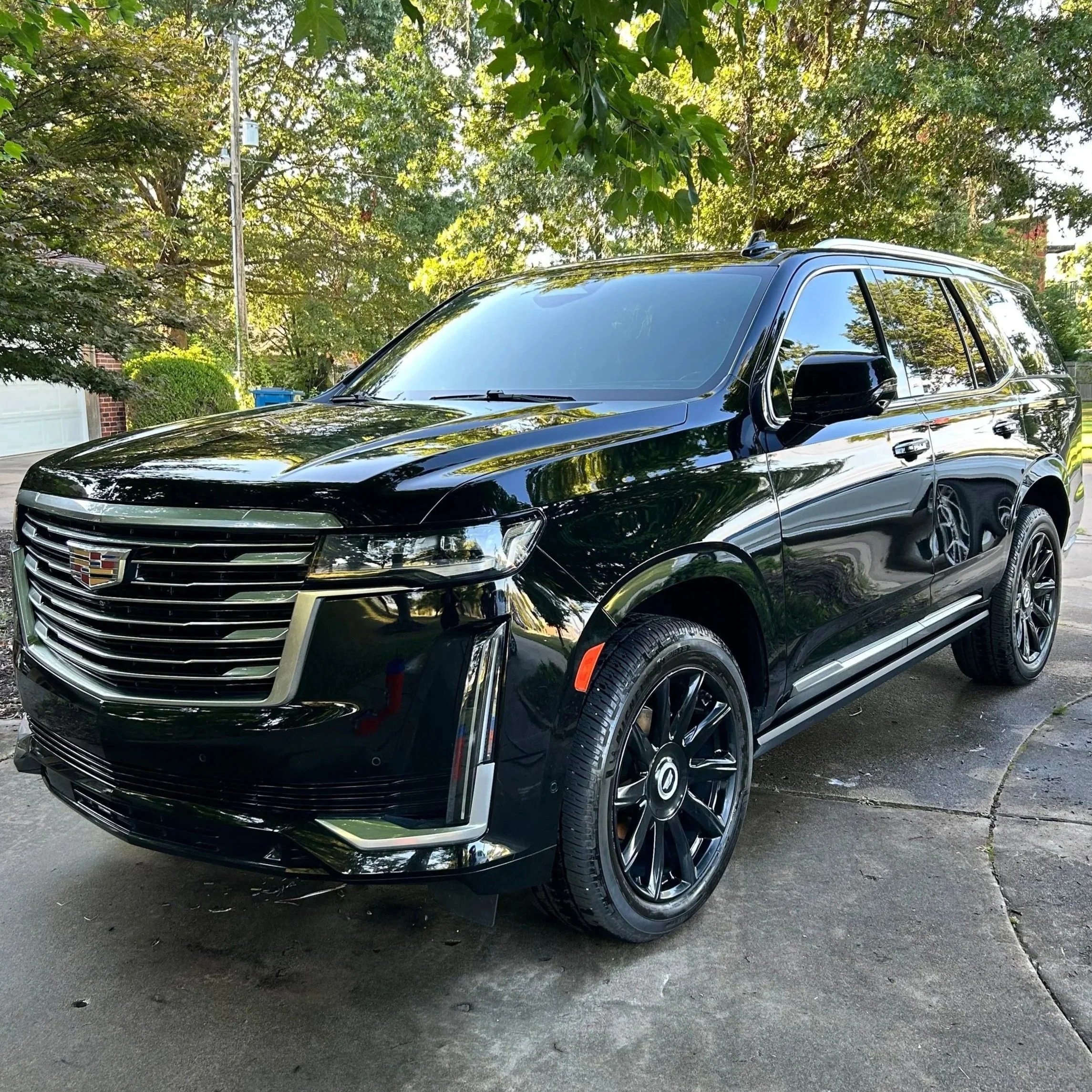 Black Cadillac SUV parked on driveway after mobile detailing in rogers arkansas including a ceramic coating.