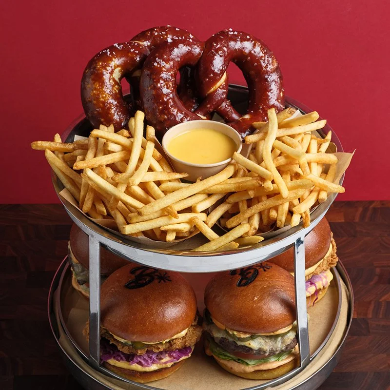 Two TV's broadcasting sports content on top of a fireplace mantle.