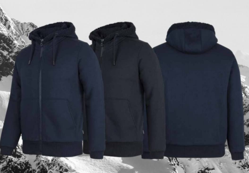 White chef's jacket with black trim buttons, laid on a wooden cutting board surface with a gray background.