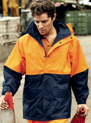 Young man in navy blue athletic polo shirt with lime green accents near a body of water.