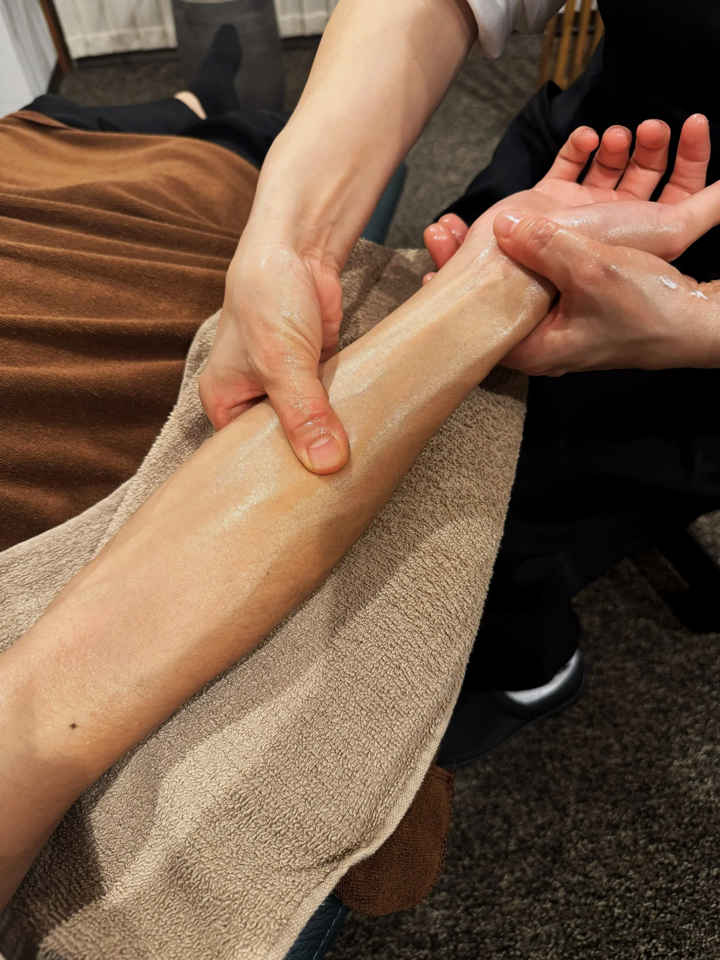 マッサージ師がお客様の腕を揉みほぐしている様子