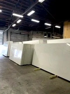 Large white stone slabs leaning against a wall in an industrial warehouse.