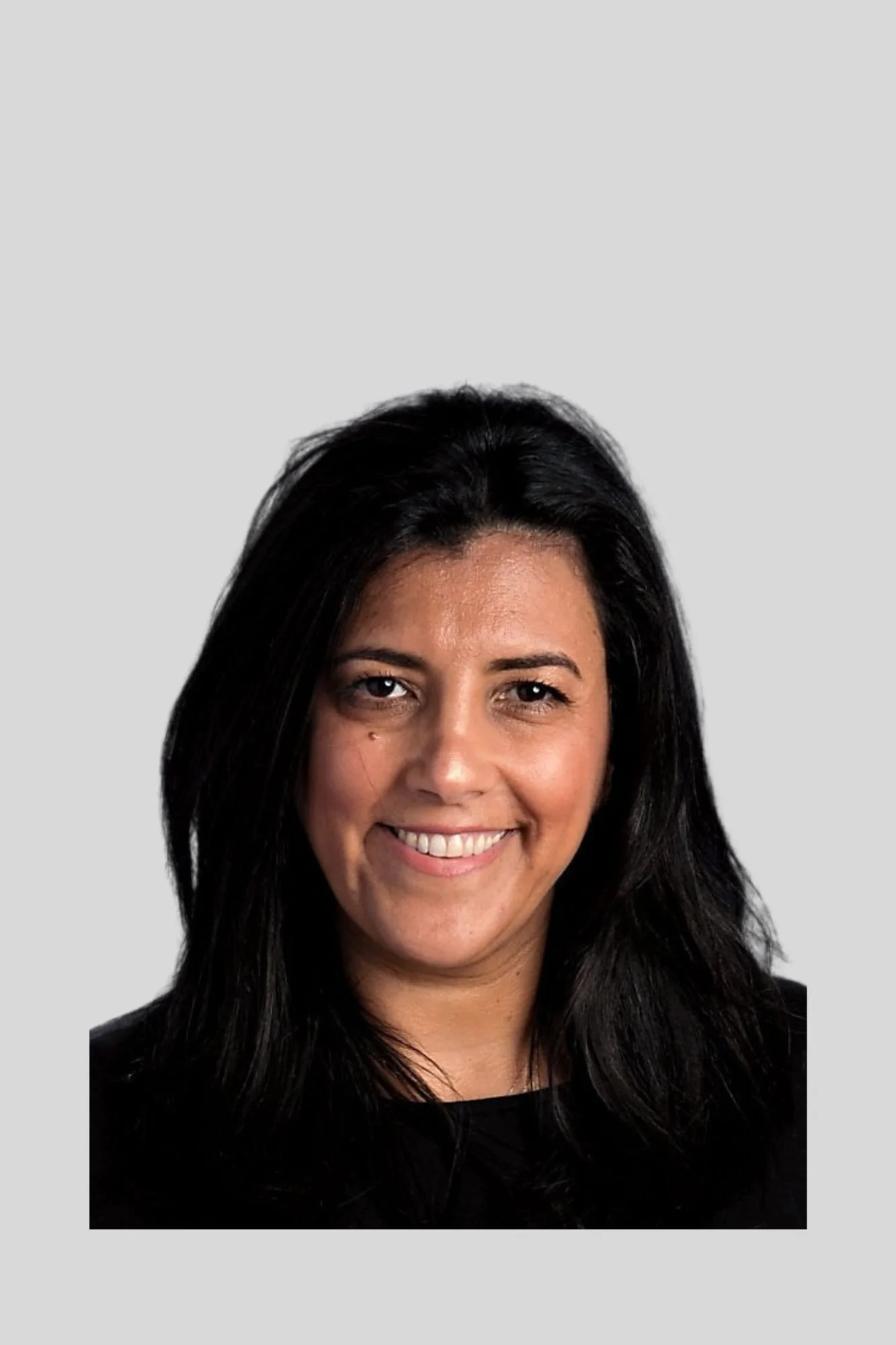 Close-up of a woman with long black hair smiling against a light gray background.