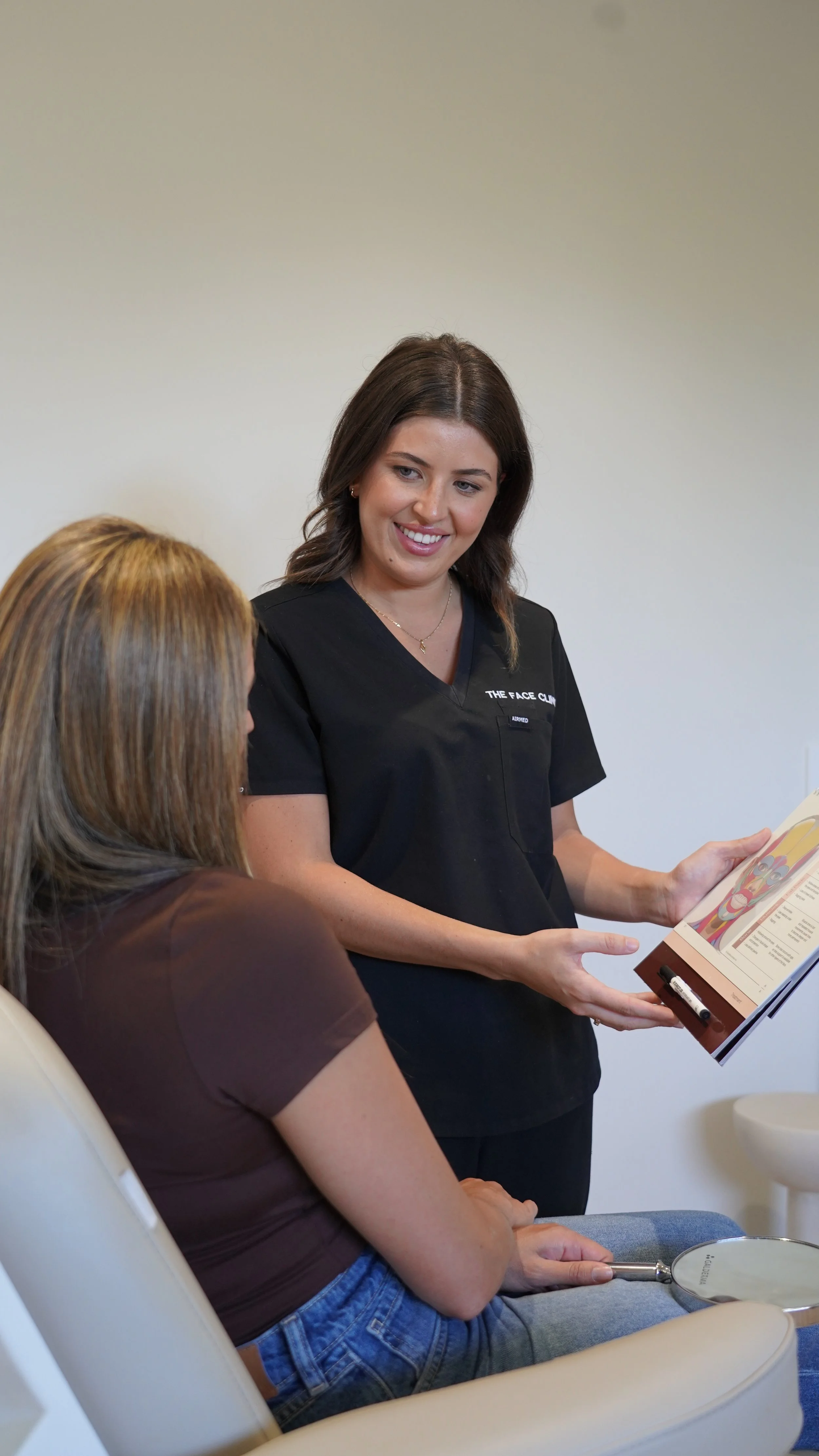 Registered cosmetic nurse Kanisha consulting with a patient at The Face Clinic, discussing personalised non-surgical cosmetic treatment options in Melbourne."