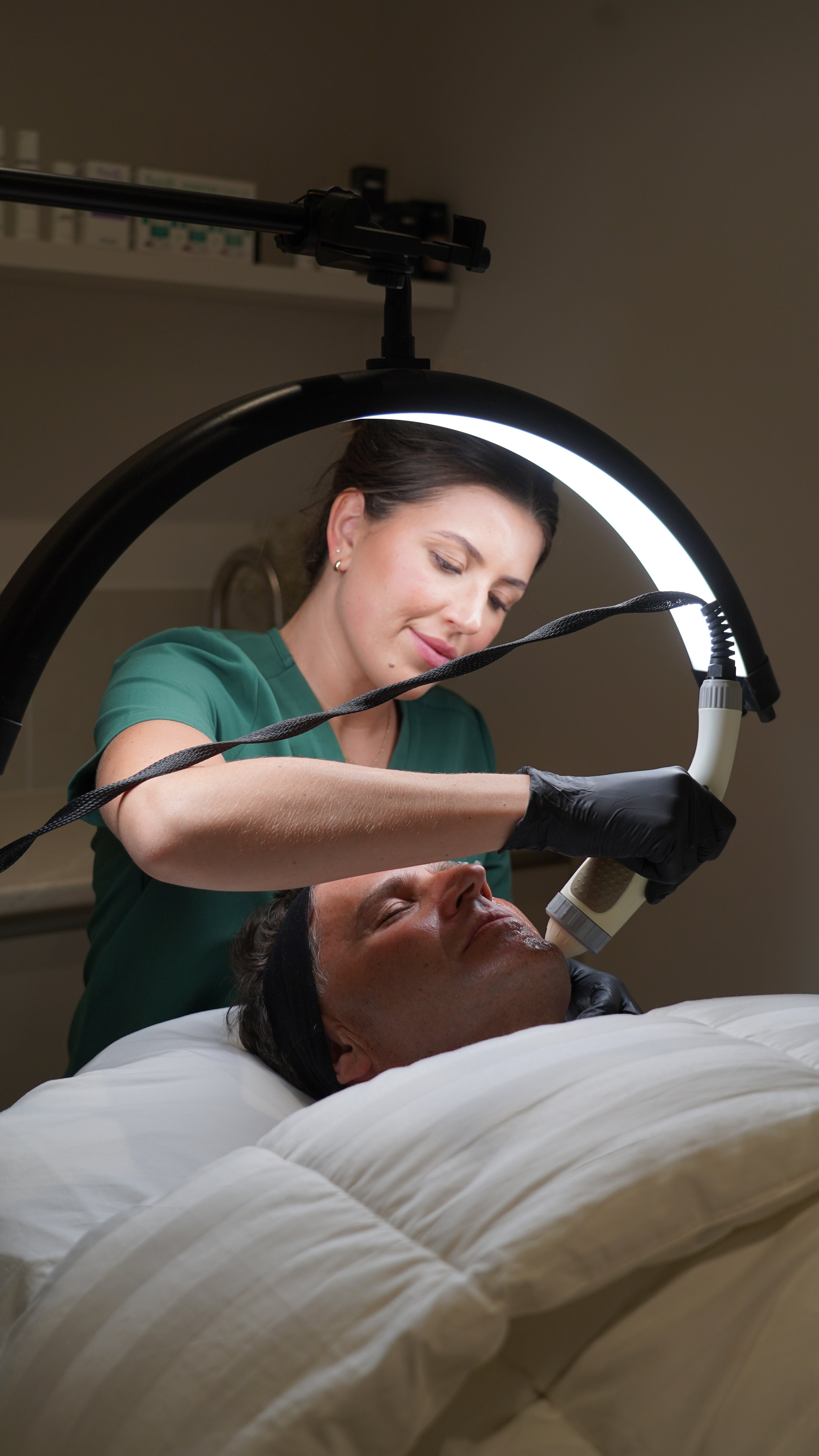 Registered cosmetic nurse Kanisha performing Radio Frequency (RF) Skin Tightening treatment on a patient at The Face Clinic in Melbourne, promoting skin firmness and rejuvenation through non-invasive cosmetic care.